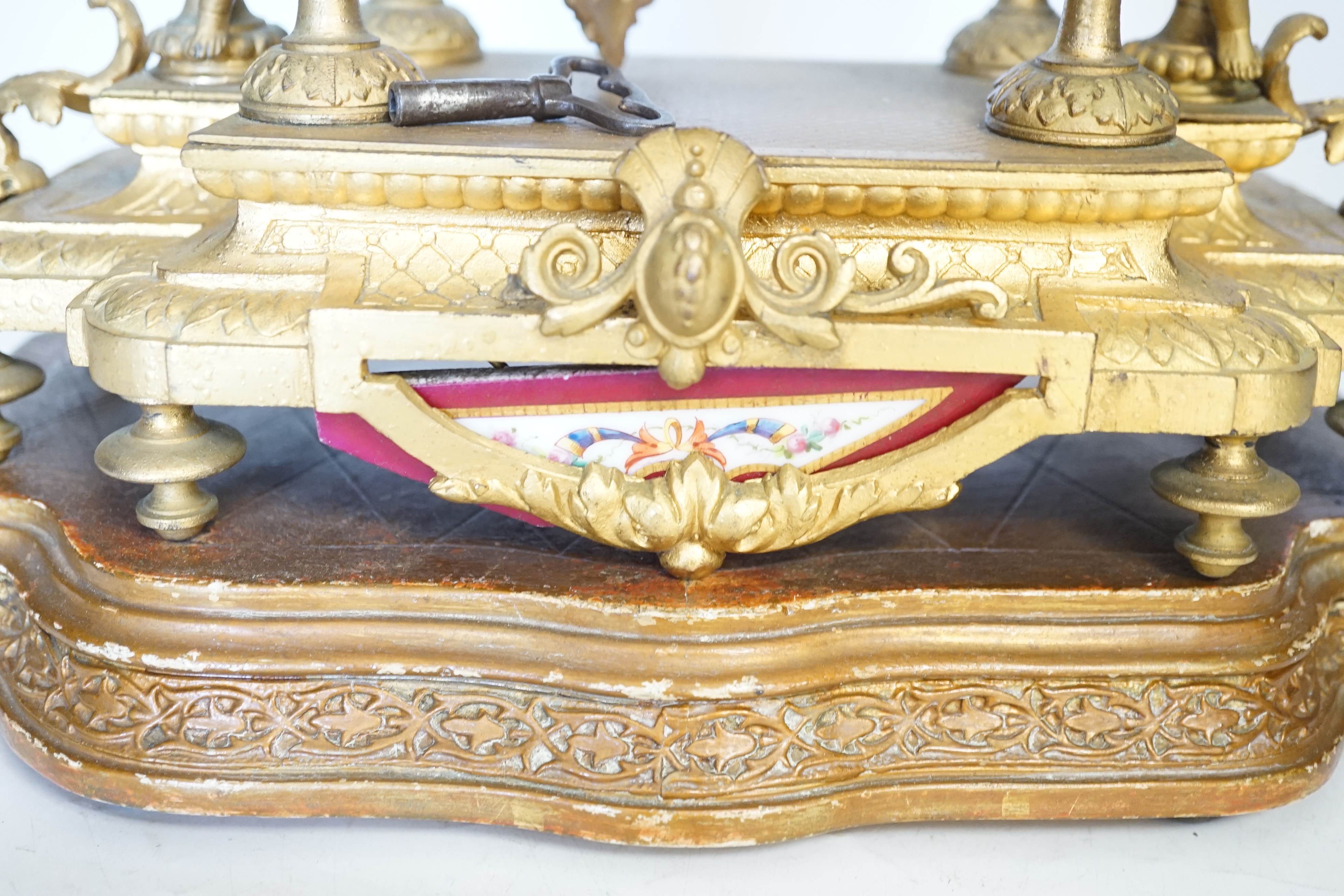 A late 19th century gilt metal and porcelain mounted mantel clock with associated stand, key and pendulum, 46cm. Condition - good to fair, not tested
